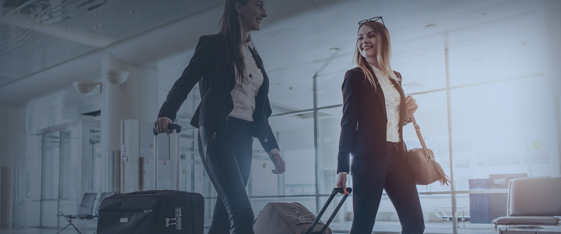 Two students at the airport with their suitcases before leaving for the United Kingdom